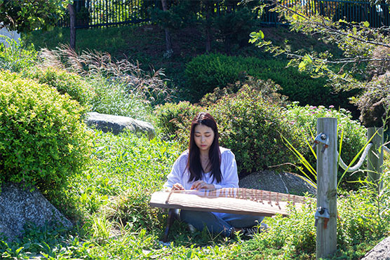 수봉공원 숲에서 촬영한 〈여백〉(2020)의 현장. 가야금을 연주하고 있는 김지효 음악가.ⓒ김민관